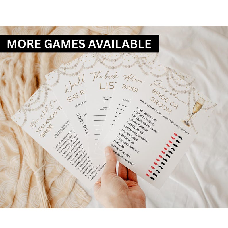 May include: A collection of white bridal shower game cards with gold text and decorative pearl accents. The games include "How Well Do You Know the Bride?" and "Guess Who Bride or Groom?" with a champagne glass illustration.