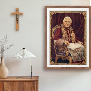 Może przedstawiać: Tkanina gobelinowa w ramie przedstawiająca mężczyznę w czerwonej szacie i białym kołnierzyku, siedzącego na złotym krześle. Gobelin jest otoczony złotą ramą i ma czerwone tło.