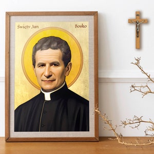 以下が含まれることがあります： 「Święty Jan Bosko」の文字が金色の額縁に入った男性の肖像画。肖像画は金色の背景に配置されています。右側の壁には木の十字架が掛かっています。