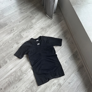 Puede incluir: Camiseta negra de manga corta con un diseño sin costuras y un pequeño logotipo en el pecho.