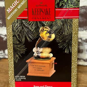 Könnte beinhalten: Hallmark Keepsake Ornament-Box mit einer Miniatur-Holzspieluhr mit Grammophon und zwei Mäusefiguren. Die Box trägt die Aufschrift "Song and Dance" und "Love and Christmas... Two reasons to celebrate!"