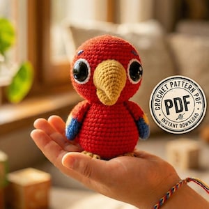 May include: A handmade red crochet bird with a yellow beak and large black eyes. The bird has blue accents on its wings and is held in a hand. A circular "PDF Instant Download" graphic is visible.
