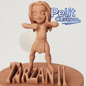 Puede incluir: Una figura marrón de un personaje de dibujos animados de Tarzán, de pie sobre una base circular con el nombre "Tarzán" en letras de bloque. La figura tiene una expresión sonriente y lleva un taparrabos. El texto "Pelit Custom" está en la esquina superior derecha.