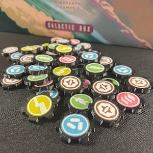 May include: A collection of colorful, round game tokens with various symbols and designs. The tokens are black with white, yellow, green, blue, and pink accents.