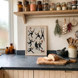 May include: A rectangular framed wall art piece featuring a textured off-white background with multiple illustrated figures in black tuxedos carrying trays of food and drinks, a seated person at a small table, and a small brown dog at the bottom.
