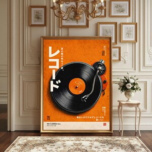 May include: A framed poster with a retro turntable design. The poster has an orange background with Japanese text and a black vinyl record. The turntable arm and base are red. The poster is displayed in a room with a chandelier and framed artwork.