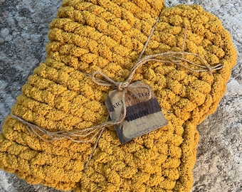 May include: A mustard yellow chunky knit throw blanket with a tag that reads "Katch A Throw Handmade Throw 30 x 35 KatchAThrow.etsy.com"