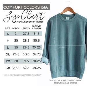 May include: Size chart for a blue spruce adult crewneck sweatshirt. The chart shows measurements in inches for width, length, and sleeve length for sizes S, M, L, XL, 2X, and 3X.