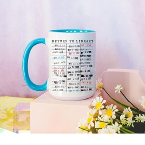 Puede incluir: Taza de cer&aacute;mica blanca con interior y asa azules. La taza presenta un dise&ntilde;o impreso que se asemeja a una tarjeta de biblioteca, con las palabras "RETURN TO LIBRARY" y varias fechas. Margaritas y una forma geom&eacute;trica en el fondo.