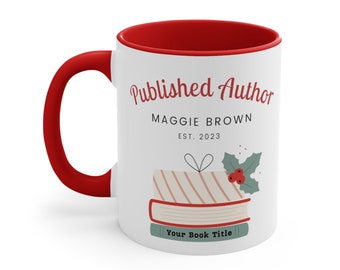 May include: White ceramic mug with a red rim. The mug has a design of a stack of books with a gift wrapped on top and a holly sprig. The text on the mug reads "Published Author Maggie Brown Est. 2023 Your Book Title"
