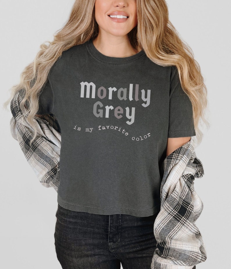 May include: A dark gray cropped t-shirt with the text "morally Grey is my favorite color" printed in a gradient of gray and pink.