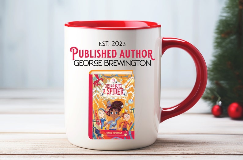 May include: White ceramic mug with a red rim and handle. The mug has the text "EST. 2023 PUBLISHED AUTHOR GEORGE BREWINGTON" printed on the front. Below the text is an illustration of a book cover with the title "The Girl Who Built a Spider" and the author's name.