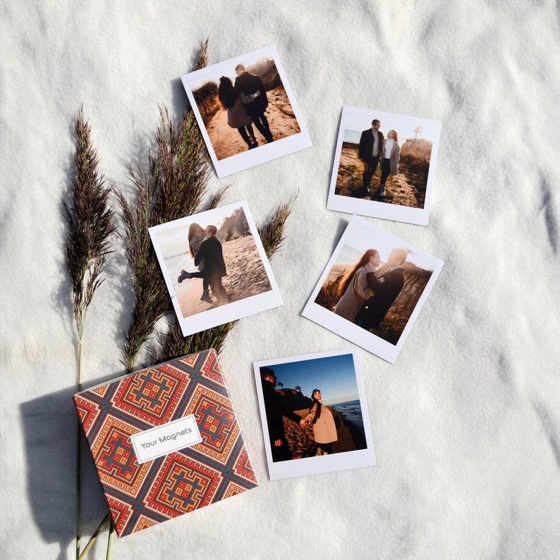 May include: Set of six square photo magnets featuring couples in various poses. The magnets are printed on white cardstock with a white border. The magnets are packaged in a small box with a colorful geometric pattern and the text "Your Magnets".