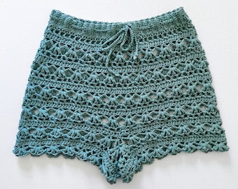 May include: Teal crochet shorts with a drawstring waist and a scalloped hem.
