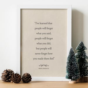 Könnte beinhalten: Ein weiß gerahmter Kunstdruck mit beigem Hintergrund und dem Zitat: I've learned that people will forget what you said, people will forget what you did, but people will never forget how you made them feel, signiert von Maya Angelou.
