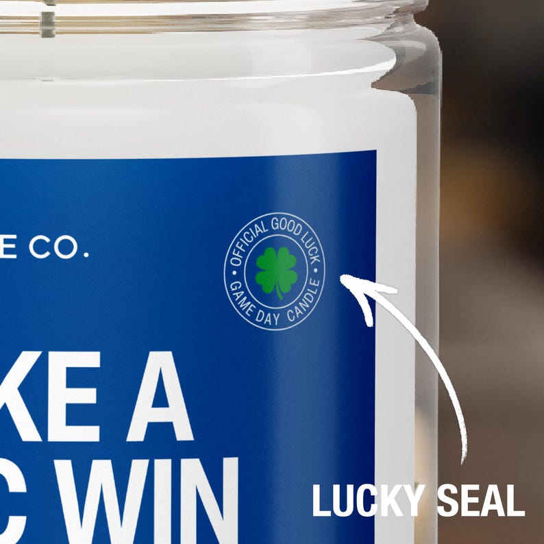 May include: A blue and white candle jar with the text "Take a Win" and a green four-leaf clover with the text "Official Good Luck Game Day Candle".