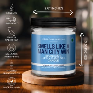 Puede incluir: Un tarro de vela de vidrio transparente con una tapa negra. La vela es blanca y tiene una etiqueta azul que dice "Smells Like A Man City Win". La etiqueta tambi&eacute;n incluye el texto "Brandon's Lucky Game Day Candle" y "Winning Sure Smells Good". La vela mide 8,9 cm de alto y 7,1 cm de ancho.