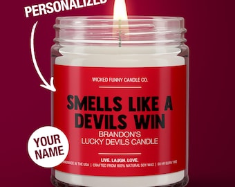 May include: A red and white candle jar with the text "Smells Like A Devils Win" and "Brandon's Lucky Devils Candle". The candle is personalized with the text "Your Name".