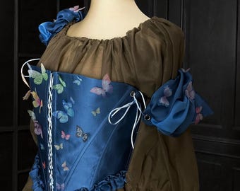 Corsé mariposa sobre el busto: Top de satén con mangas drapeadas y corsé con apliques.