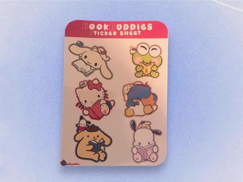 May include: A sticker sheet with the text "Book Buddies Sticker Sheet" at the top. The sheet features seven colorful stickers of cartoon characters reading books. The characters include a frog, a penguin, a kitty, a dog, and a bunny.