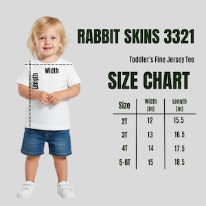 May include: A toddler wearing a white t-shirt and blue denim shorts. The image includes a size chart for toddler fine jersey tees, with measurements in inches for sizes 2T to 5-6T. The text "RABBIT SKINS 3321" is at the top.