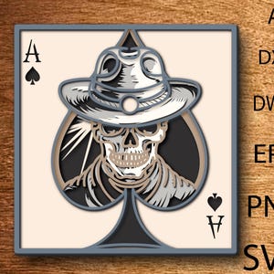 May include: A framed Ace of Spades card design featuring a skull wearing a hat. The card is in a gray frame with the Ace of Spades symbol and the letter "A" in the top left corner. The card also has the Ace of Spades symbol and the letter "V" in the bottom right corner.