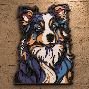 May include: A multi-layered wooden wall art piece depicting a dog with a tri-colour coat. The design features intricate cutouts in shades of blue, purple, orange, white, and black, creating a dimensional portrait of a canine with alert eyes.