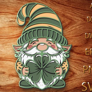 May include: A layered gnome design holding a four-leaf clover, featuring a green and yellow striped hat, a white beard, and a smiling face. The design is set against a wood grain background, with file type labels on the right.