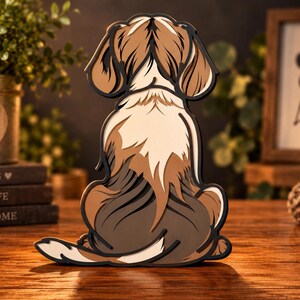 May include: A multi-layered wooden wall art piece shaped like a dog sitting with its back to the viewer. The dog features brown, white, and dark gray segments with black outlines, creating a dimensional effect that highlights the fur patterns.