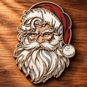 Op de afbeelding: Een meerlaags houten wanddecoratie die het gezicht van de Kerstman weergeeft. Het ontwerp bevat een rode muts met een witte pompon, dikke witte wenkbrauwen, een volle witte baard en een ronde bril, allemaal met diepte en uitsparingen.