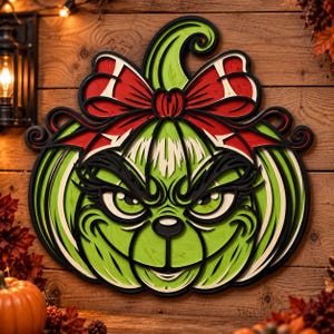 May include: A layered wooden wall decoration shaped like a pumpkin with a green character face, featuring a large red bow on top. The design includes black outlines, a curved stem, and expressive eyes with long eyelashes, all crafted in a multi-dimensional style.