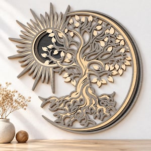 Könnte beinhalten: Ein mehrschichtiges Wandbild aus Holz mit einem zentralen Baum, dessen Äste und Wurzeln kunstvoll ausgearbeitet sind. Das Motiv wird links von einer strahlenden Sonne und rechts von einer Mondsichel eingerahmt, in hellen und dunkelgrauen Holztönen.