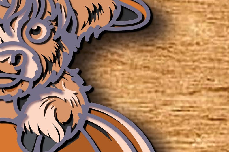 May include: A layered paper art piece depicting a stylised dog's head. The artwork uses shades of brown, tan, and grey, with a detailed design and a shadow effect. The background is a light brown wood grain.