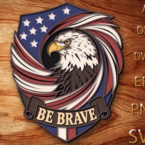 May include: A layered design featuring an American bald eagle within a shield shape. The eagle is depicted with white and brown feathers, a yellow beak, and piercing eyes. The shield incorporates the American flag's colors and stars, with the text "BE BRAVE" on a banner.