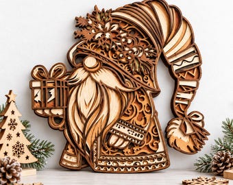 May include: A multi-layered wooden wall art piece depicting a gnome with a long beard, wearing a tall, patterned hat adorned with snowflake and holly motifs, holding a gift box, with a separate wooden Christmas tree ornament nearby.