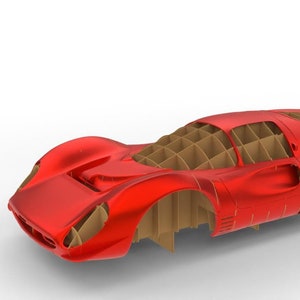 May include: A red model car with a cardboard interior. The car is a classic race car design with a long hood and a low profile.