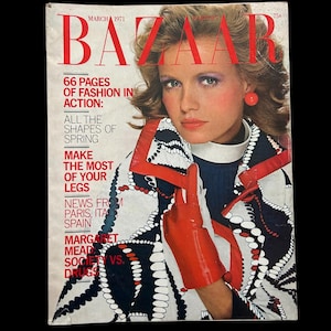 以下が含まれることがあります： 1971年3月号のヴィンテージBazaar誌の表紙。金髪と赤いイヤリングをした女性が特徴です。「66ページのファッション」と「あなたの足を最大限に活用する」というテキストが含まれています。女性は柄物のジャケットと赤い手袋を着用しています。
