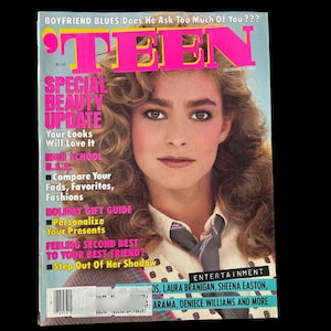 May include: A vintage magazine cover featuring a woman with curly hair. The magazine title is "TEEN" in pink and yellow. Headlines include "Special Beauty Update" and "Holiday Gift Guide". The cover also lists entertainment names.