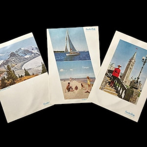 May include: Three vintage travel postcards featuring scenic views. One shows a mountain range with snow, another a sailboat and beach scene, and the third a person in a red coat near a tall building. Each postcard has a white border.