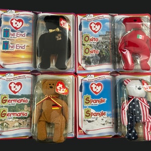 May include: Collection of Beanie Baby bears in their original packaging. The bears are various colors, including black, brown, red, and white, and are dressed in outfits representing different countries. Each bear is in a clear plastic case.