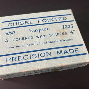 May include: A light blue box of Empire 1/4" cohered wire staples, model 1325. The box reads "Chisel Pointed" and "Precision Made" in blue text. The box contains 5000 staples and is for use in Speed 13 and similar machines.