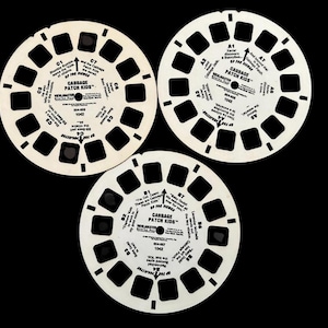 May include: Three vintage Cabbage Patch Kids View-Master reels on a black background. Each reel is white with black text and square viewing windows. The text includes the title, episode details, and instructions.