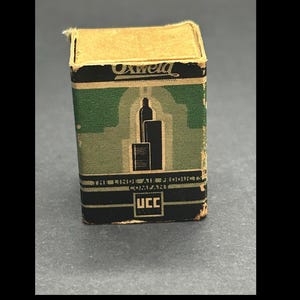 May include: Vintage Oxweld product box. The box is rectangular with a tan top and a green and black patterned body. The front of the box features a graphic of two black cylinders and the text "THE LINDE AIR PRODUCTS COMPANY" and "UCC".