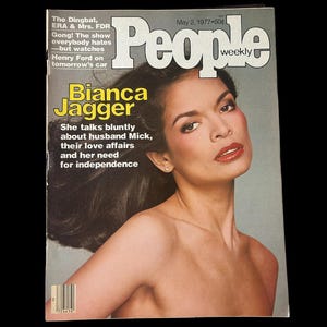 以下が含まれることがあります： 1977年5月2日のPeople Weekly誌のヴィンテージ表紙。ビアンカ・ジャガーが特集されています。表紙には、黒髪と赤い口紅のジャガーの肖像画が描かれています。雑誌のタイトルは白で、発行日と価格が上部にあります。