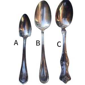 May include: Three antique silver spoons are displayed against a white background. Each spoon has a different design, with varying bowl shapes and handle details. The spoons are labeled A, B, and C.