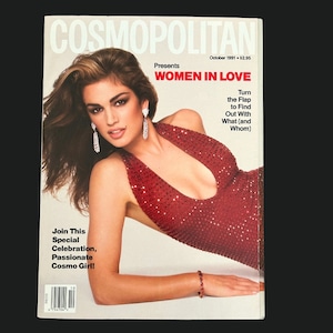 May include: Cosmopolitan magazine cover featuring a woman in a red sequined dress. The cover text reads "WOMEN IN LOVE" and "October 1991". The magazine cover also includes the text "Join This Special Celebration, Passionate Cosmo Girl!"