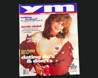 May include: A vintage YM magazine cover featuring Paula Abdul. The cover includes text about fashion, dating, and beauty. The magazine has a red and white color scheme with the text "YM" in blue.