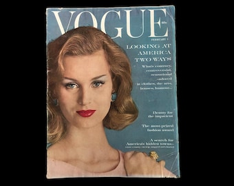 May include: A vintage Vogue magazine cover from February 1960. The cover shows a woman with red lipstick and a pink top. The magazine title is in large white letters, with the headline "LOOKING AT AMERICA TWO WAYS."