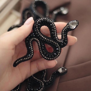 Broche de cuentas de serpiente en color negro y plateado. Accesorio decorativo gótico con forma de serpiente para chaqueta, bolso, cartera, sombrero, bufanda o zapatos