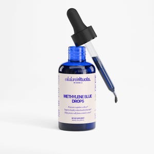 Puede incluir: Una botella de vidrio azul de gotas de azul de metileno con un cuentagotas negro. La etiqueta dice "olalanirituals" y "METHYLENE BLUE DROPS". La botella contiene 60 ml de l&iacute;quido. El cuentagotas est&aacute; lleno de l&iacute;quido azul.